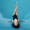 A woman sits in a bright blue pool