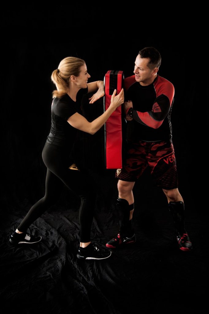 A man and woman practicing martial arts on a black background.