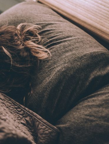 woman sleeping on bed under blankets